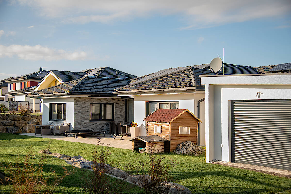 Moderne Wohnsiedlung mit Einfamilienhäusern, gepflegtem Garten und Spielplatz.