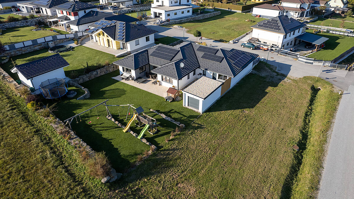 Luftaufnahme einer Wohnsiedlung mit Spielplatz und modernen Einfamilienhäusern.